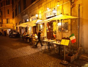 Rome, Italy - Sep 16, 2015: Tourists and local residents enjoying the night life, dining in outdoor street restaurants in the center of Rome, Italy.